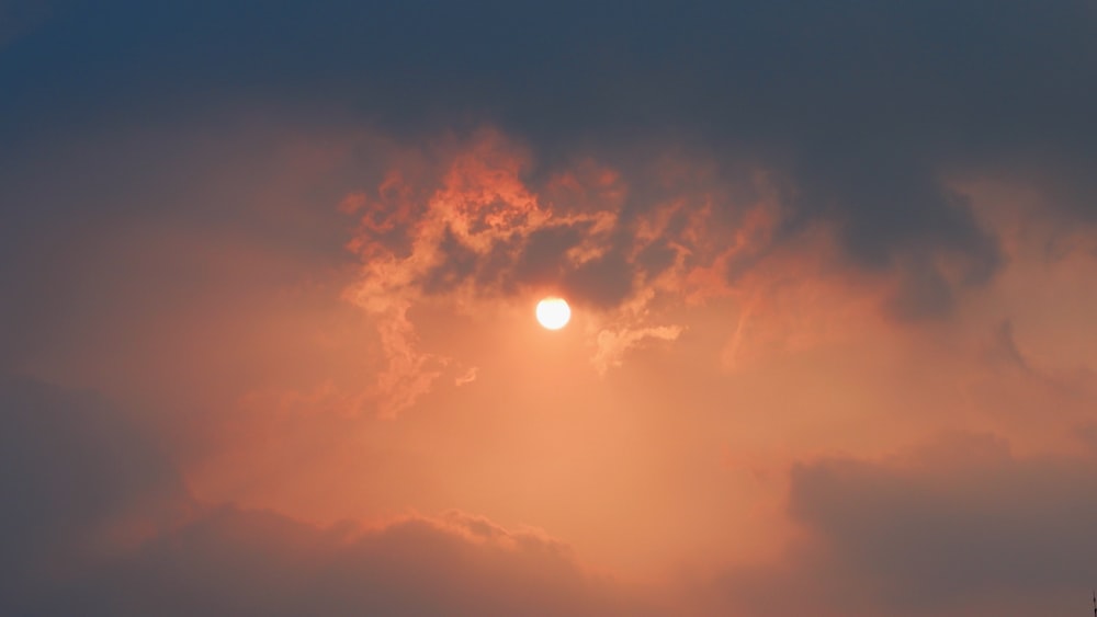 Die Sonne geht am bewölkten Himmel unter