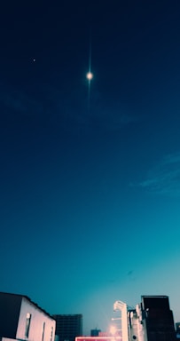 A serene night sky with stars shining over a quiet European cityscape in deep blue and gold tones.