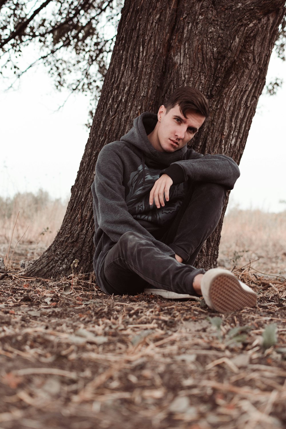 man leaning on tree during daytime