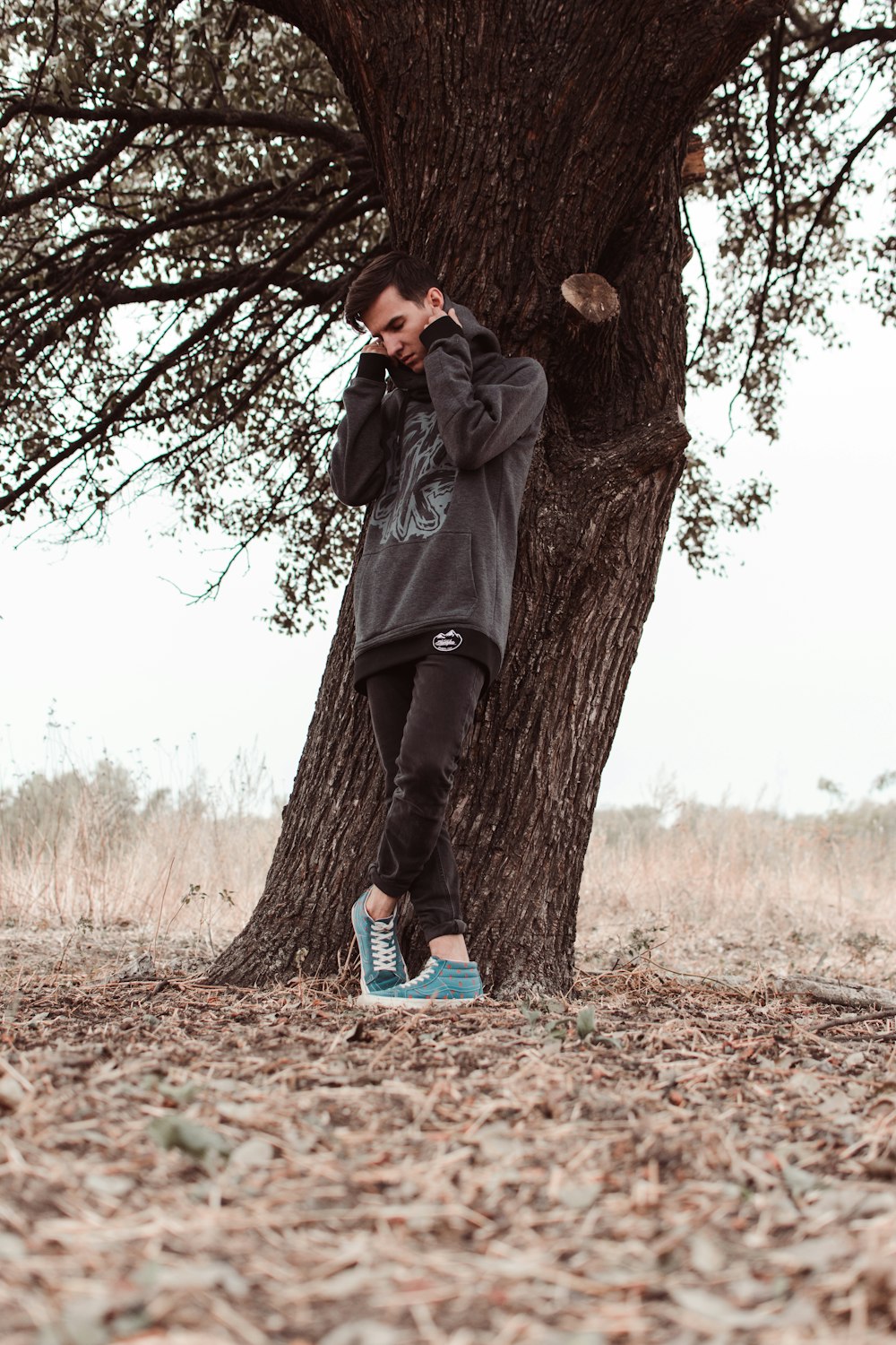 man leaning on tree