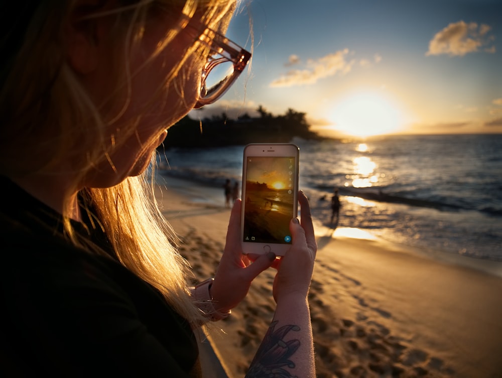 woman taking picture of beach