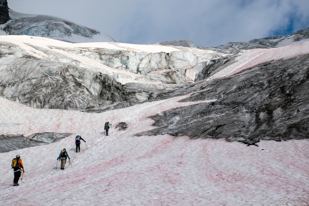 four people climbing on mountain