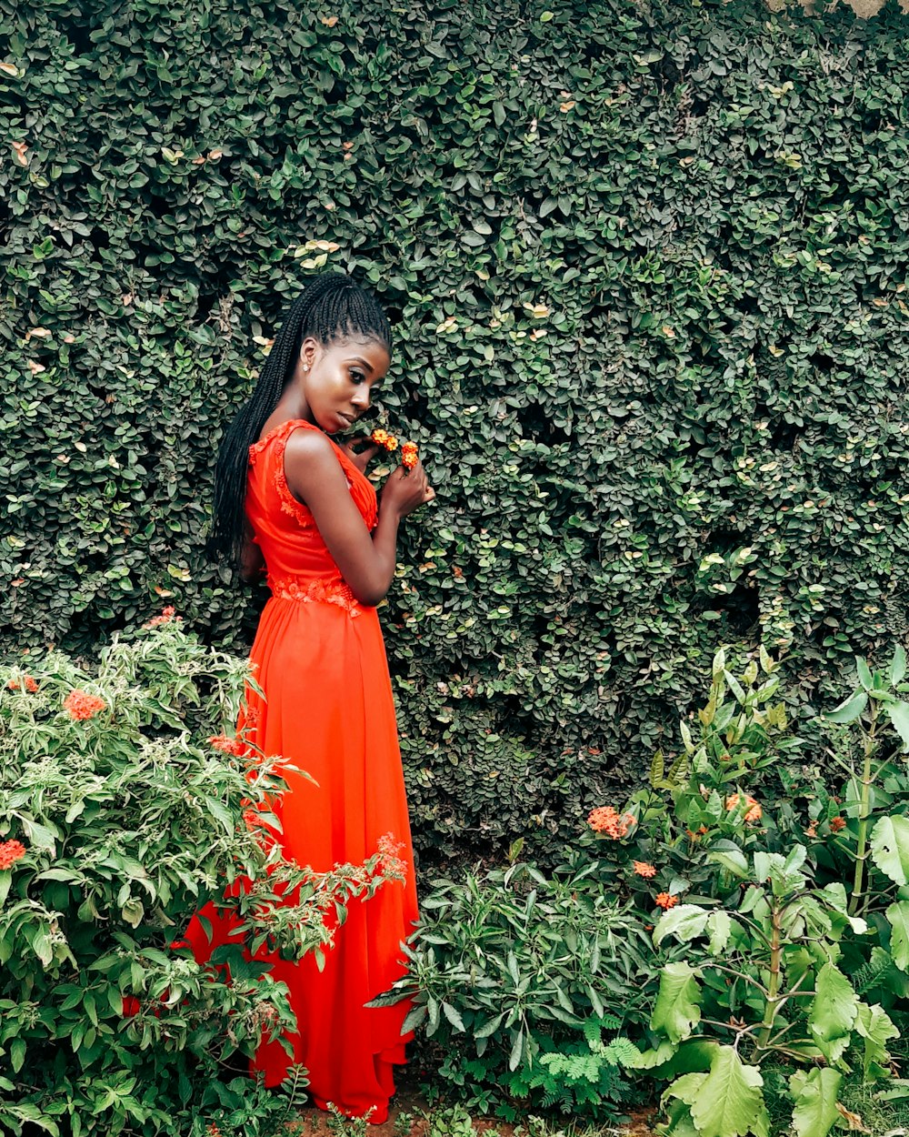 standing woman beside hedge