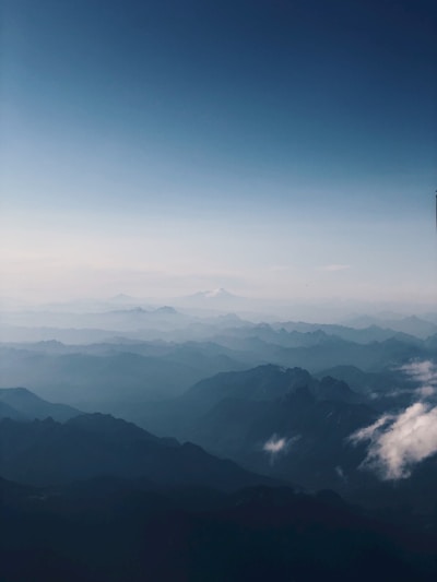A sweeping landscape shot capturing the vastness of a misty mountain range at dawn.