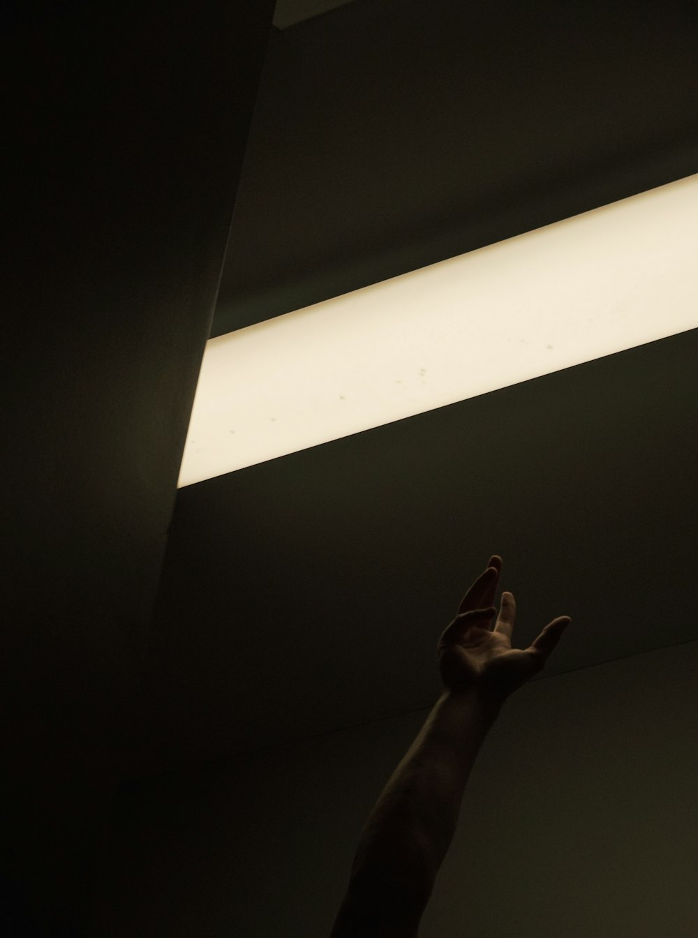 a person reaching up into the ceiling with their hand