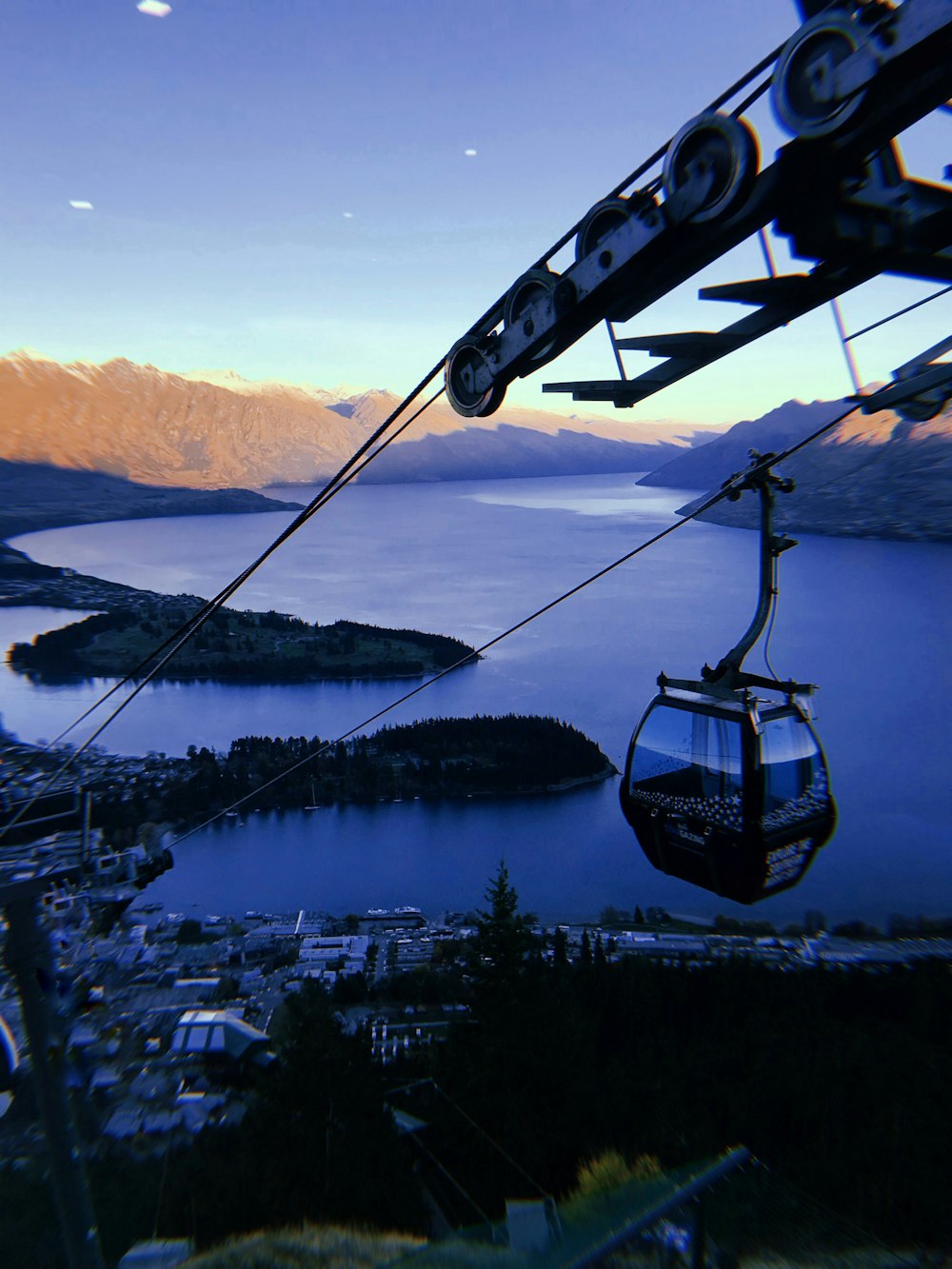 cable cart above trees and buildings on island during day