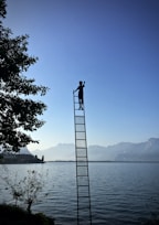 boy on ladder under blue sky