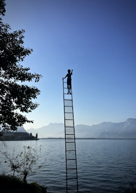 boy on ladder under blue sky