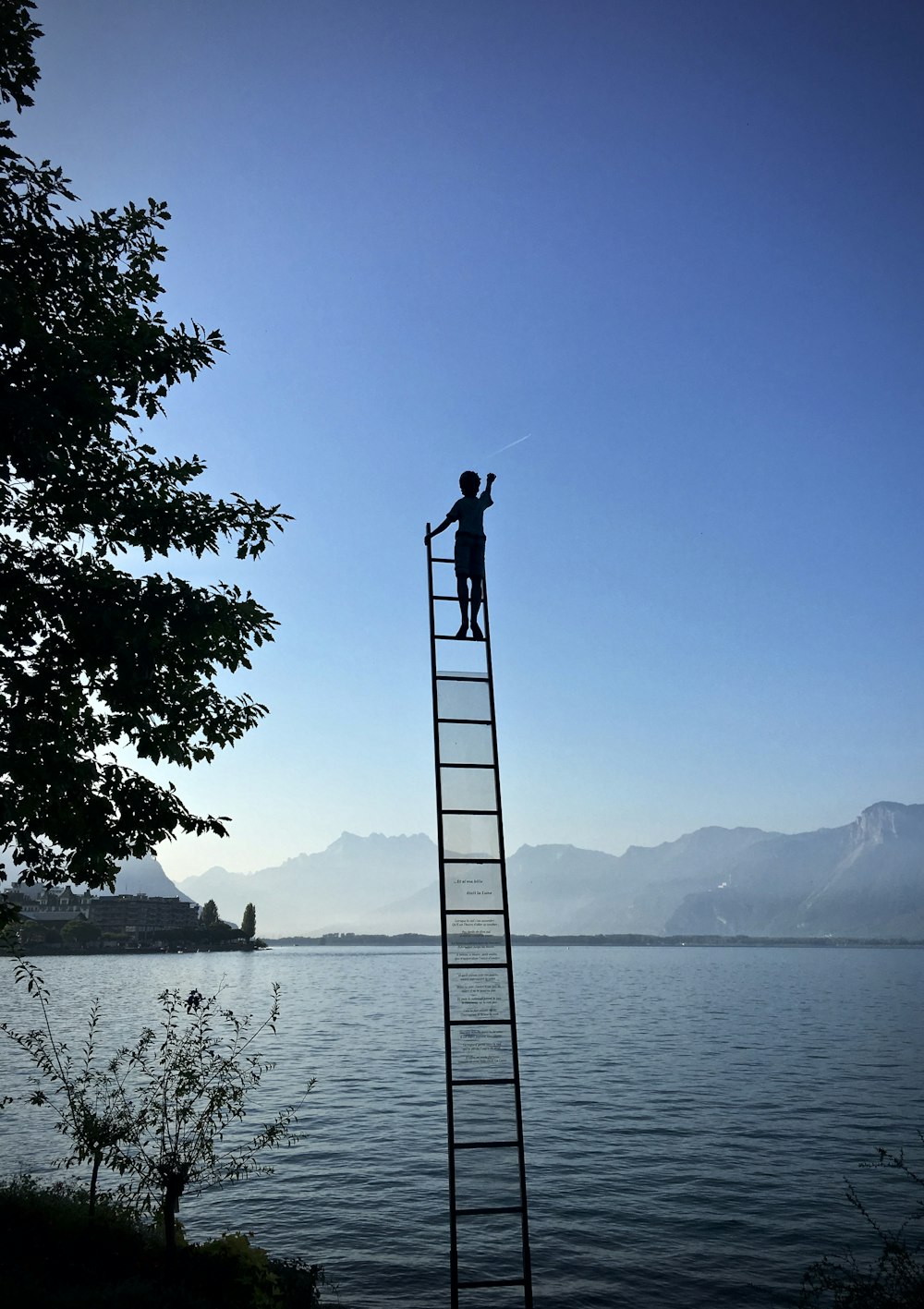 boy on ladder under blue sky