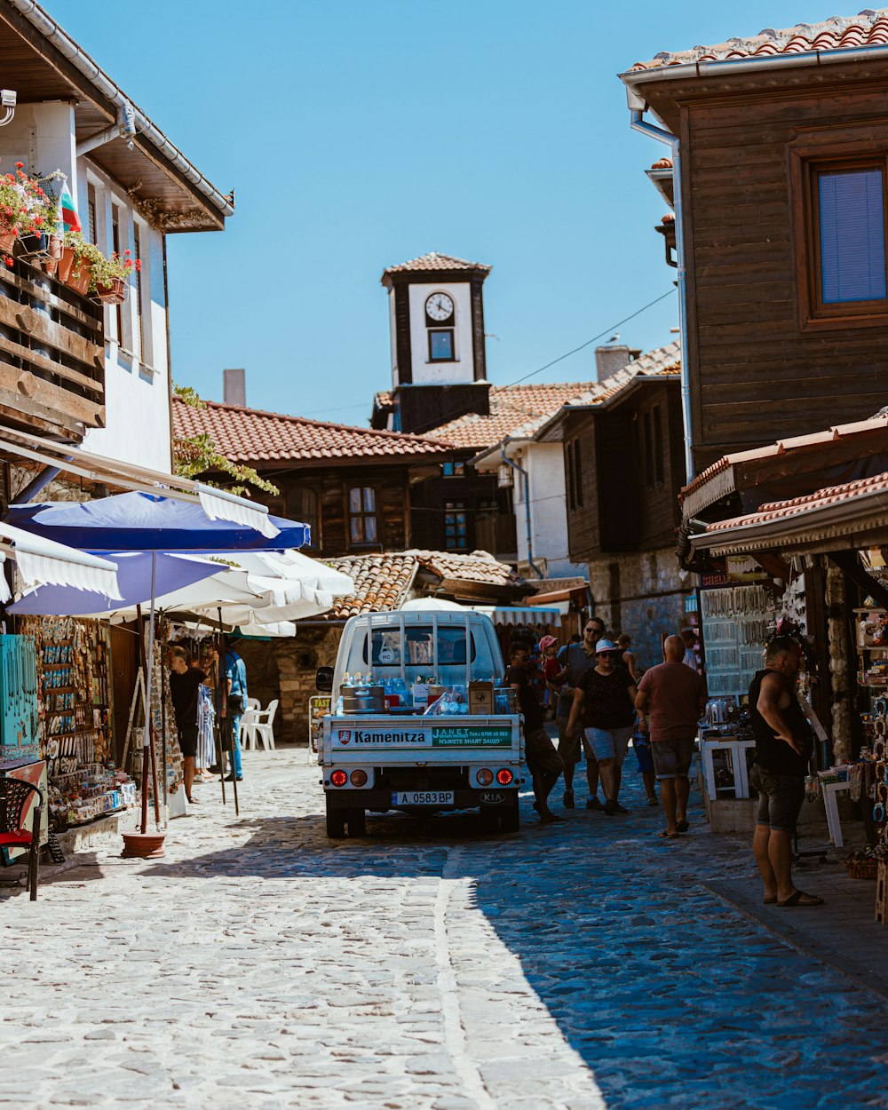 white kei truck passing between structures