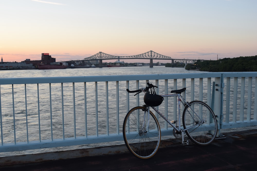 bicycle leaning on railing near water