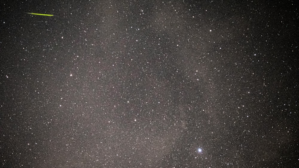 the night sky with stars and a bright green object