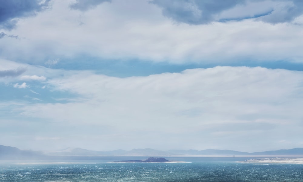 a large body of water sitting under a cloudy sky