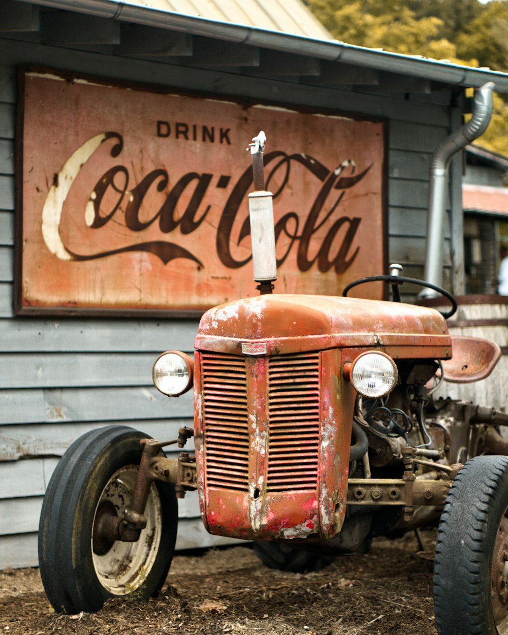 brown tractor beside Coca-Cola sign