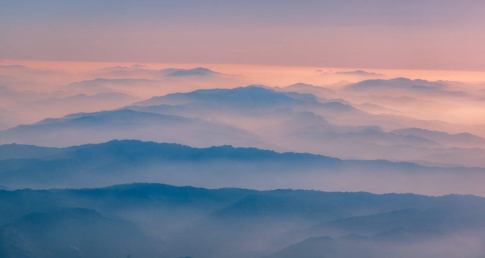 high-angle photography of mountains surrounded by clouds