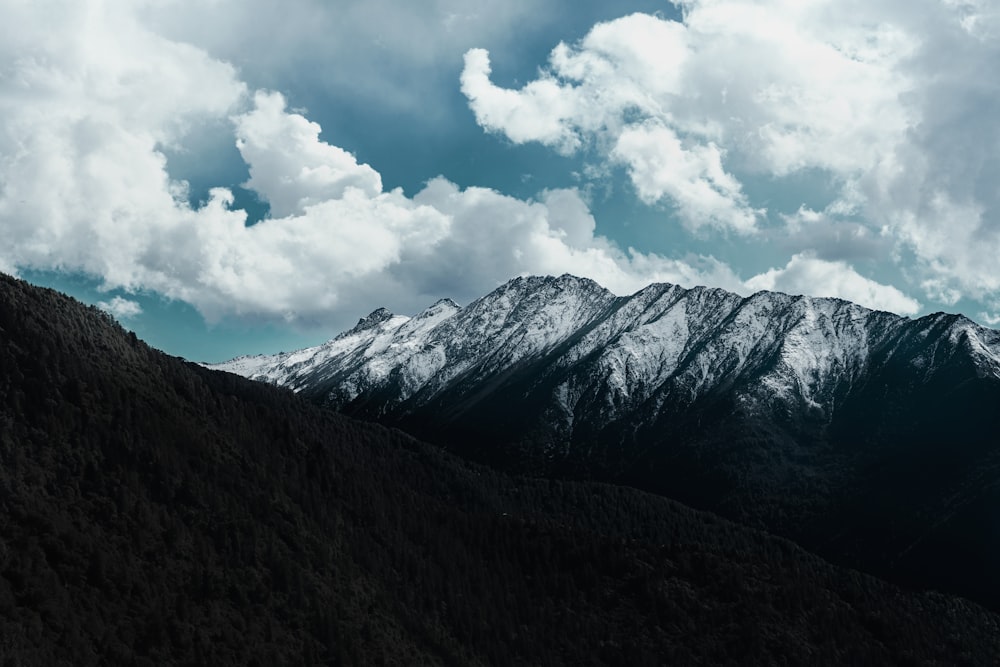 montanha coberta de neve sob nuvens brancas