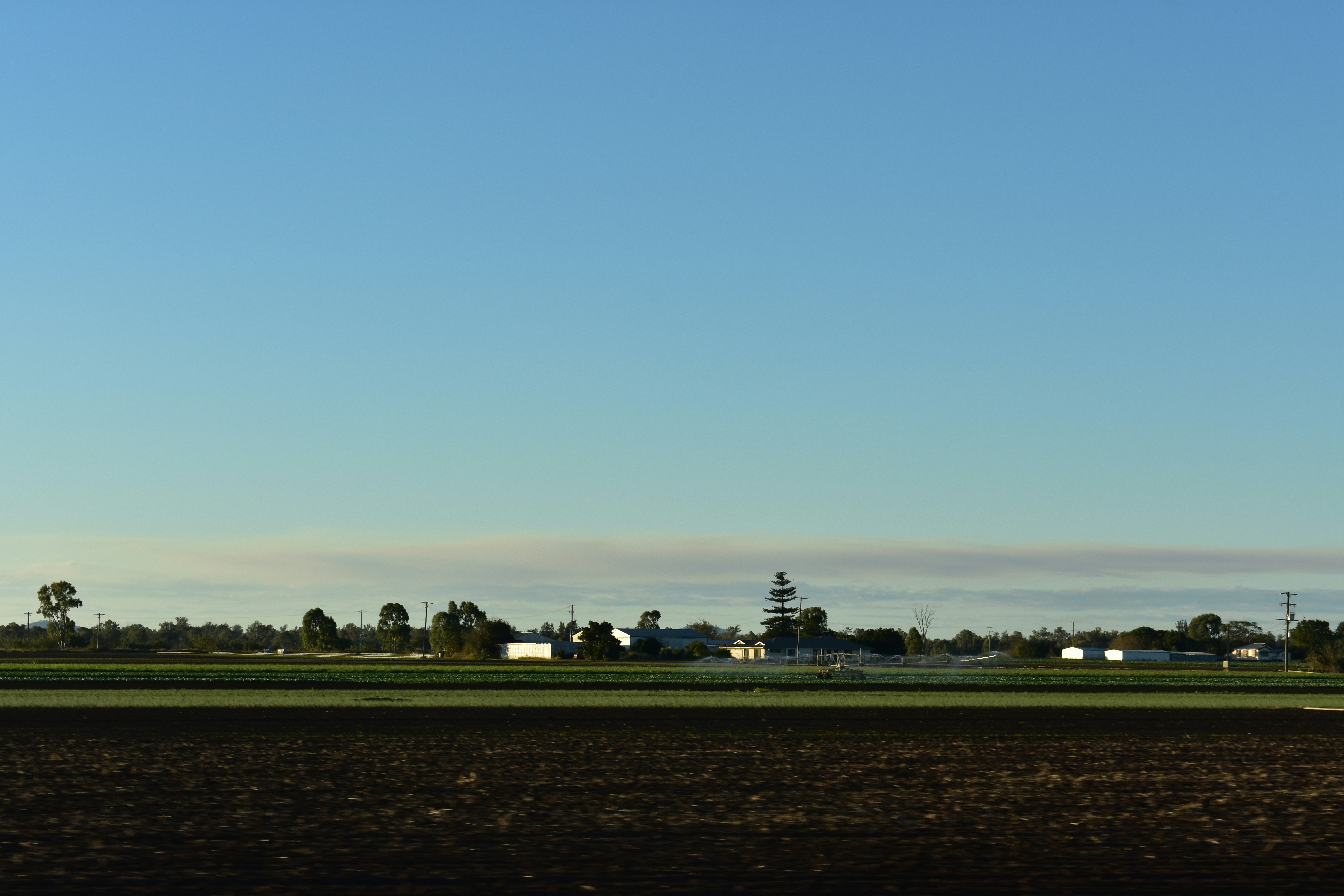 a plane flying in the sky over a field
