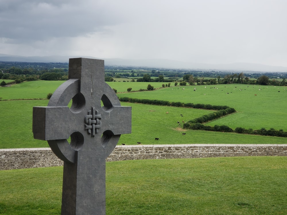croix en béton gris sur un champ d’herbe pendant la journée