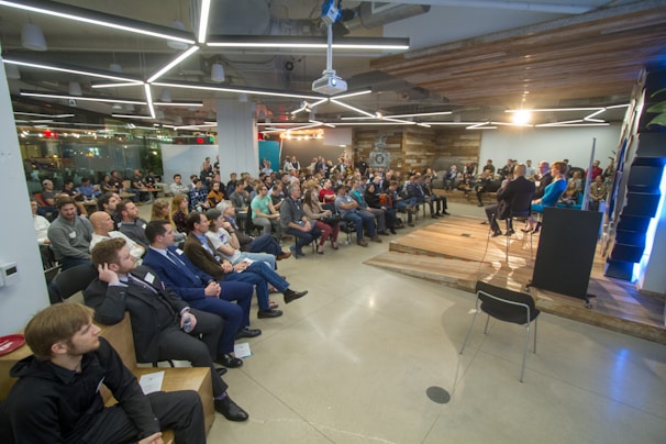 A diverse group of people engaged in a respectful community debate in a bright meeting room.