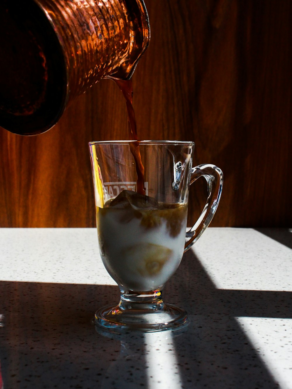 person pouring beverage on cup