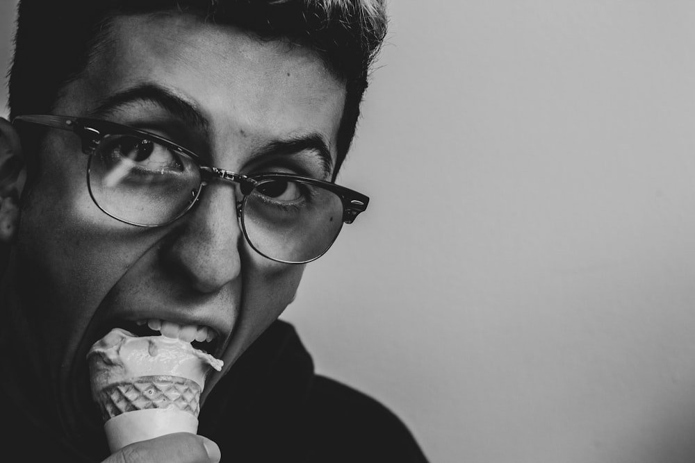 grayscale photo of person eating ice cream