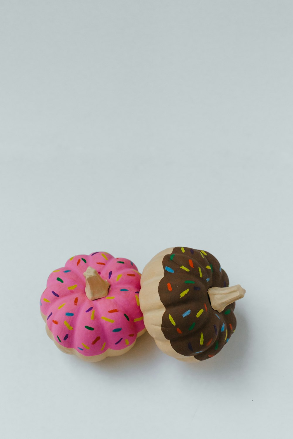 two strawberry and chocolate pumpkin doughnut toy