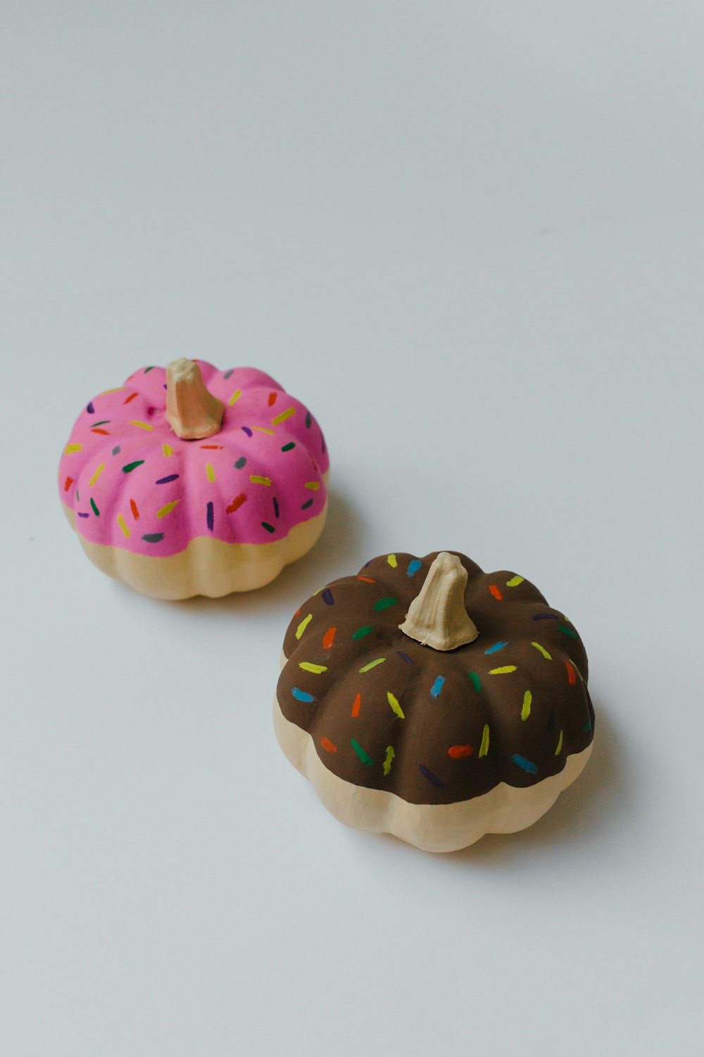 two decorative pumpkins on white surface