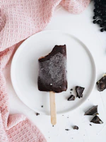 Rich chocolate ice cream melting slightly on a rustic wooden table