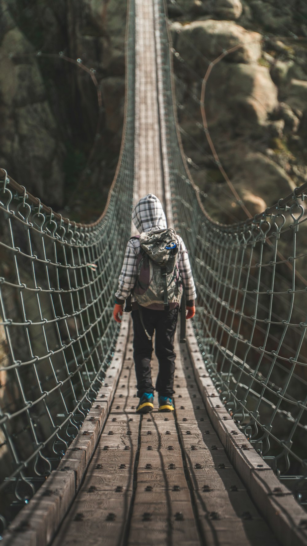 unknown person standing on gray hanging bridge