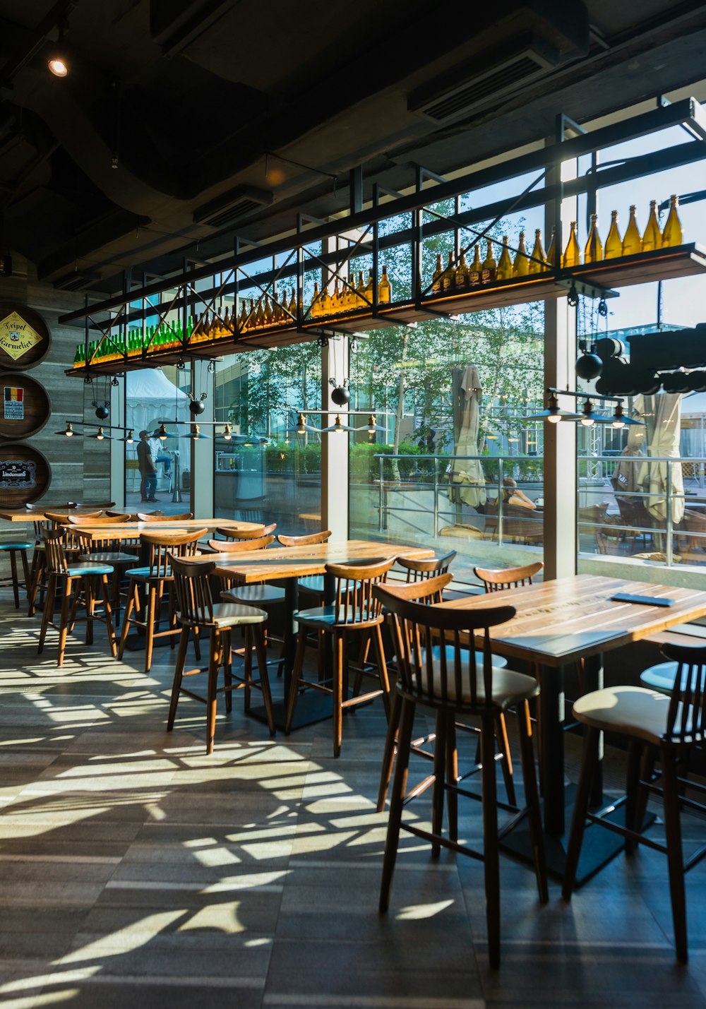 empty brown wooden table and chairs beside glass wall