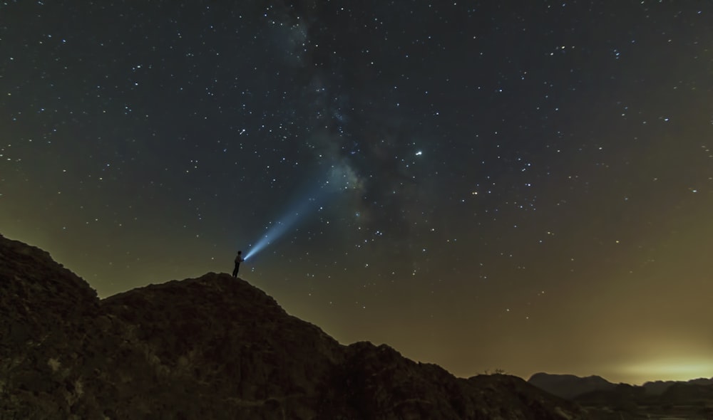 silhouette of mountain under starry night