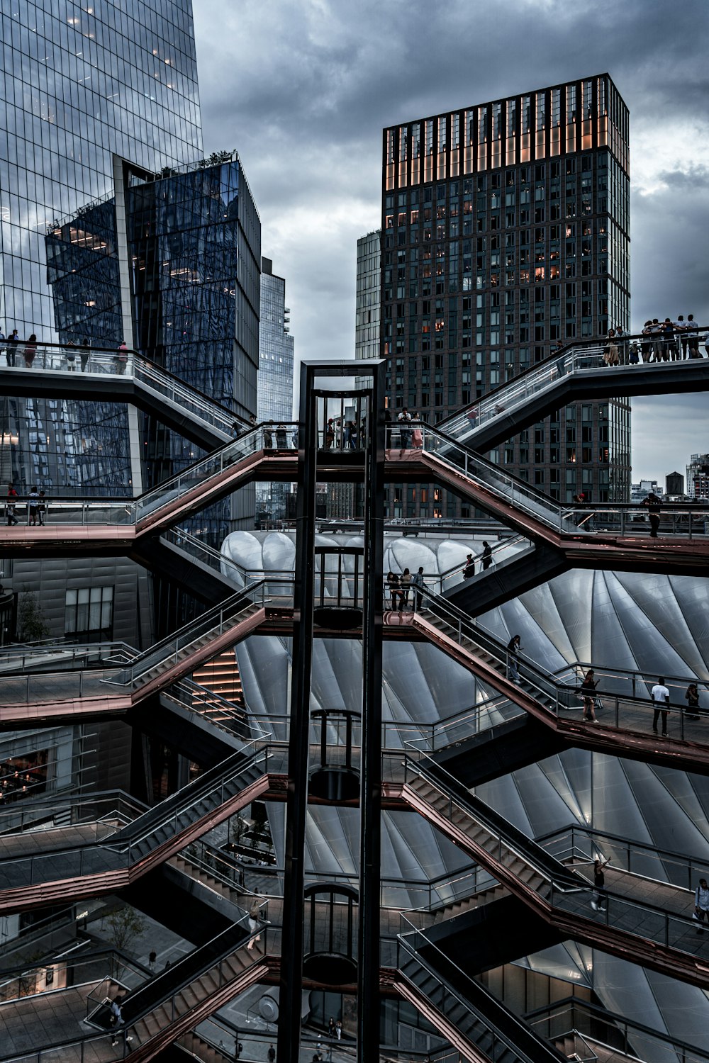 Menschen, die tagsüber in der Nähe von Hochhäusern mit Blick auf graue Gebäude mit Glaswänden spazieren gehen