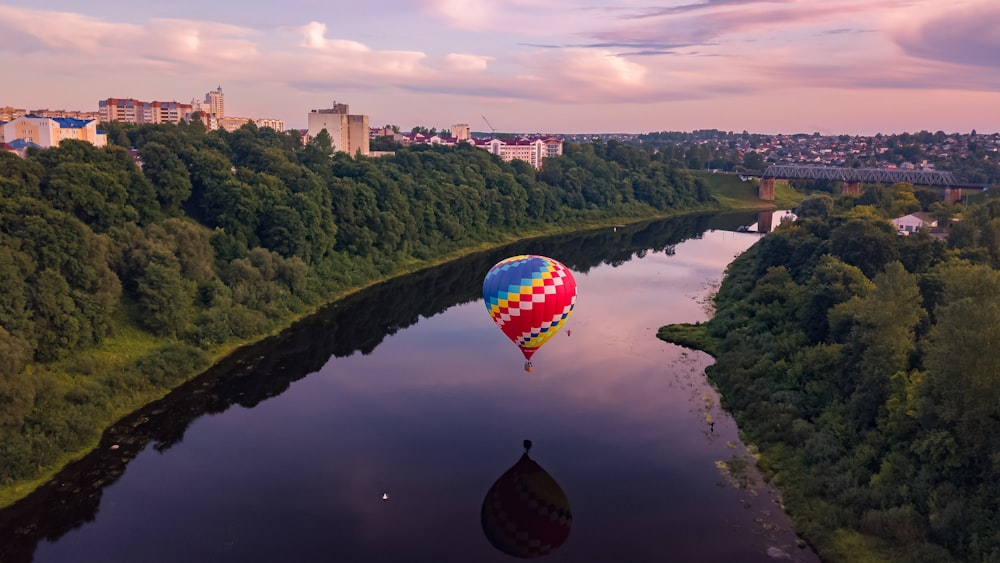 balão de ar quente vermelho, amarelo e azul no topo do lago