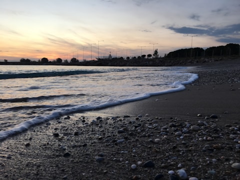 Sunset beach scene with 'pleasher' glowing softly over the horizon.