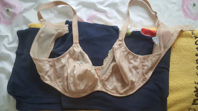 Flat lay of delicate lace bras and panties in beige and white.