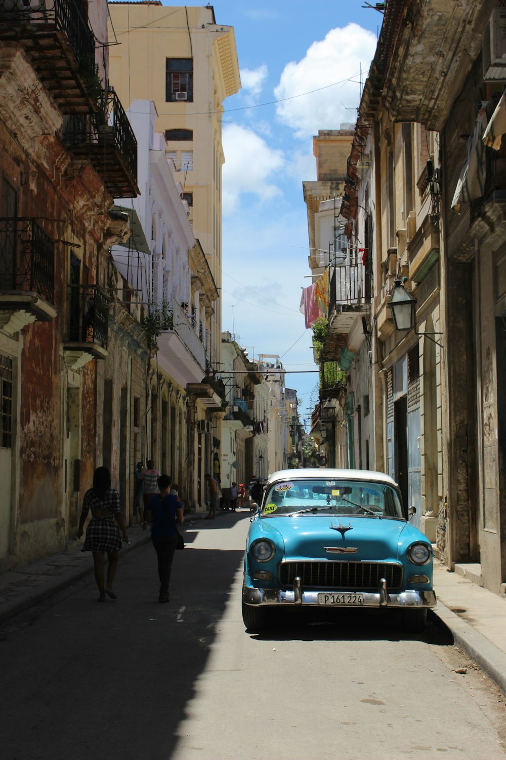 teal Chevrolet Bel-Air on road near sidewalk