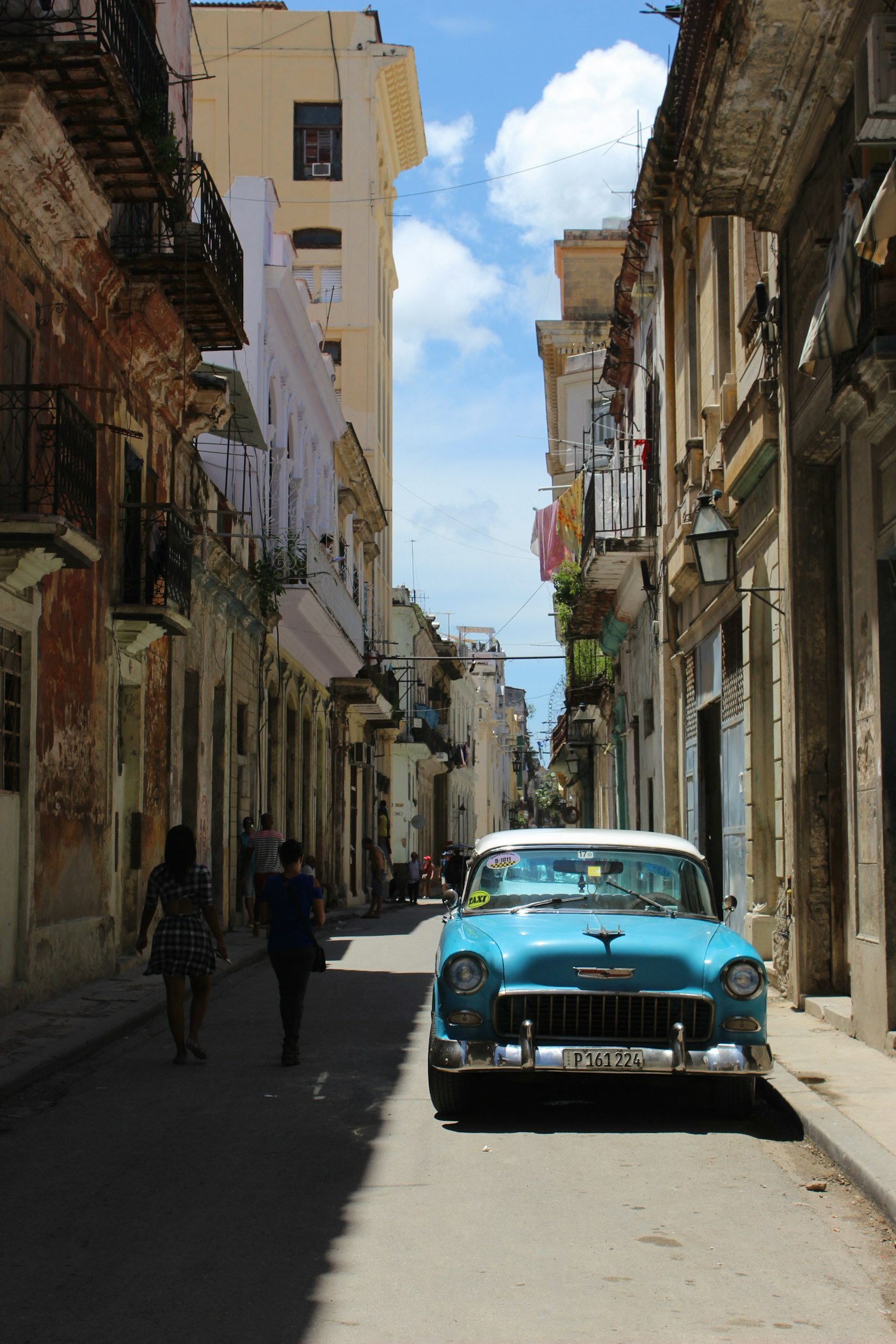 Chevrolet Bel-Air verde azulado en calle de La Habana con acera y edificios clásicos cubanos