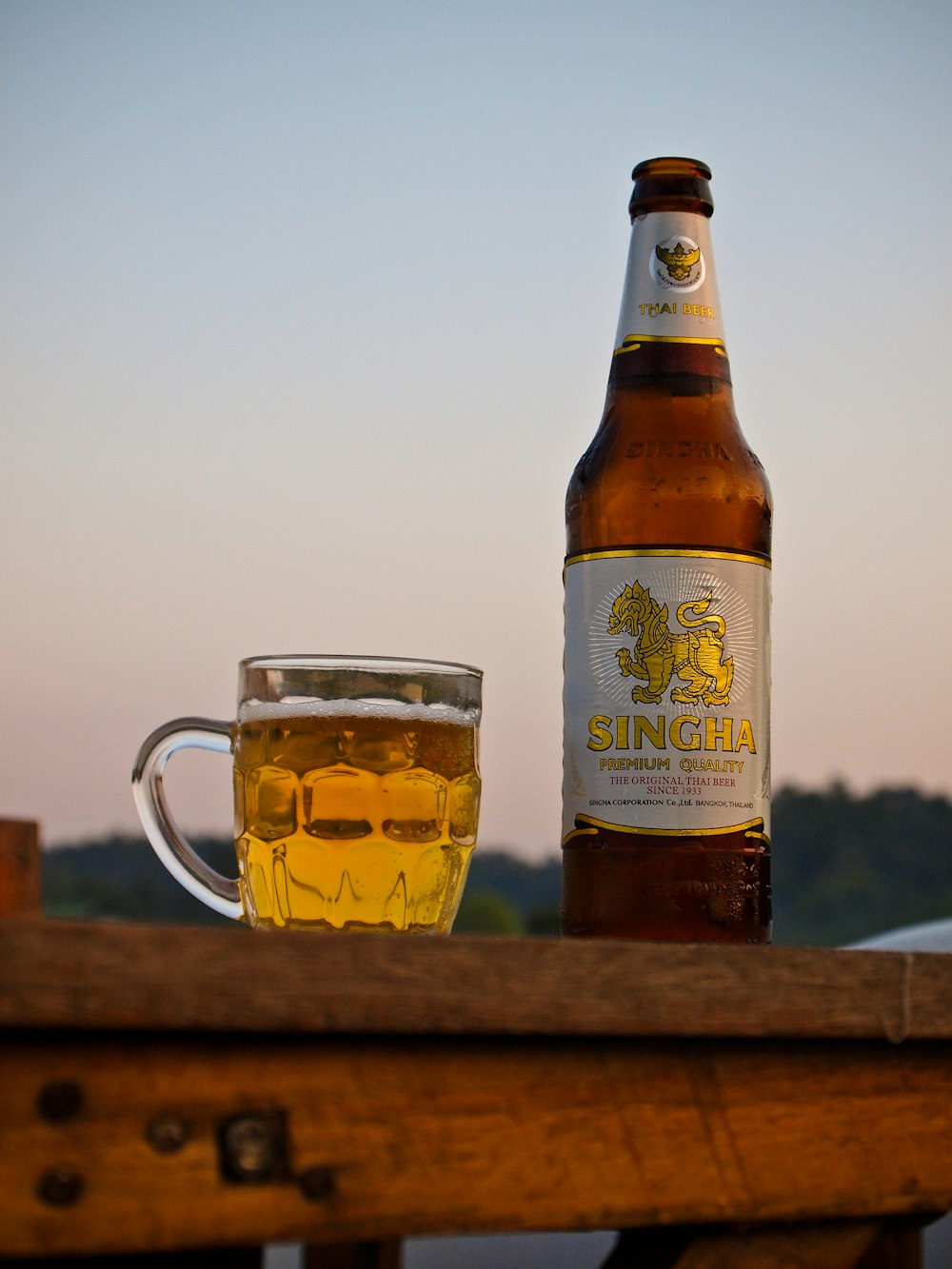 amber glass bottle beside beer mug