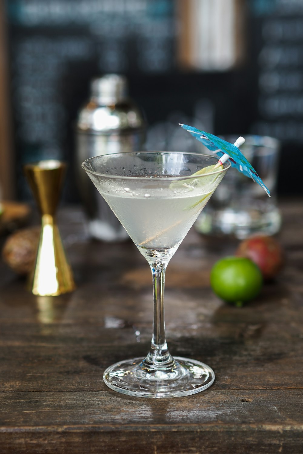martini glass with blue cocktail umbrella