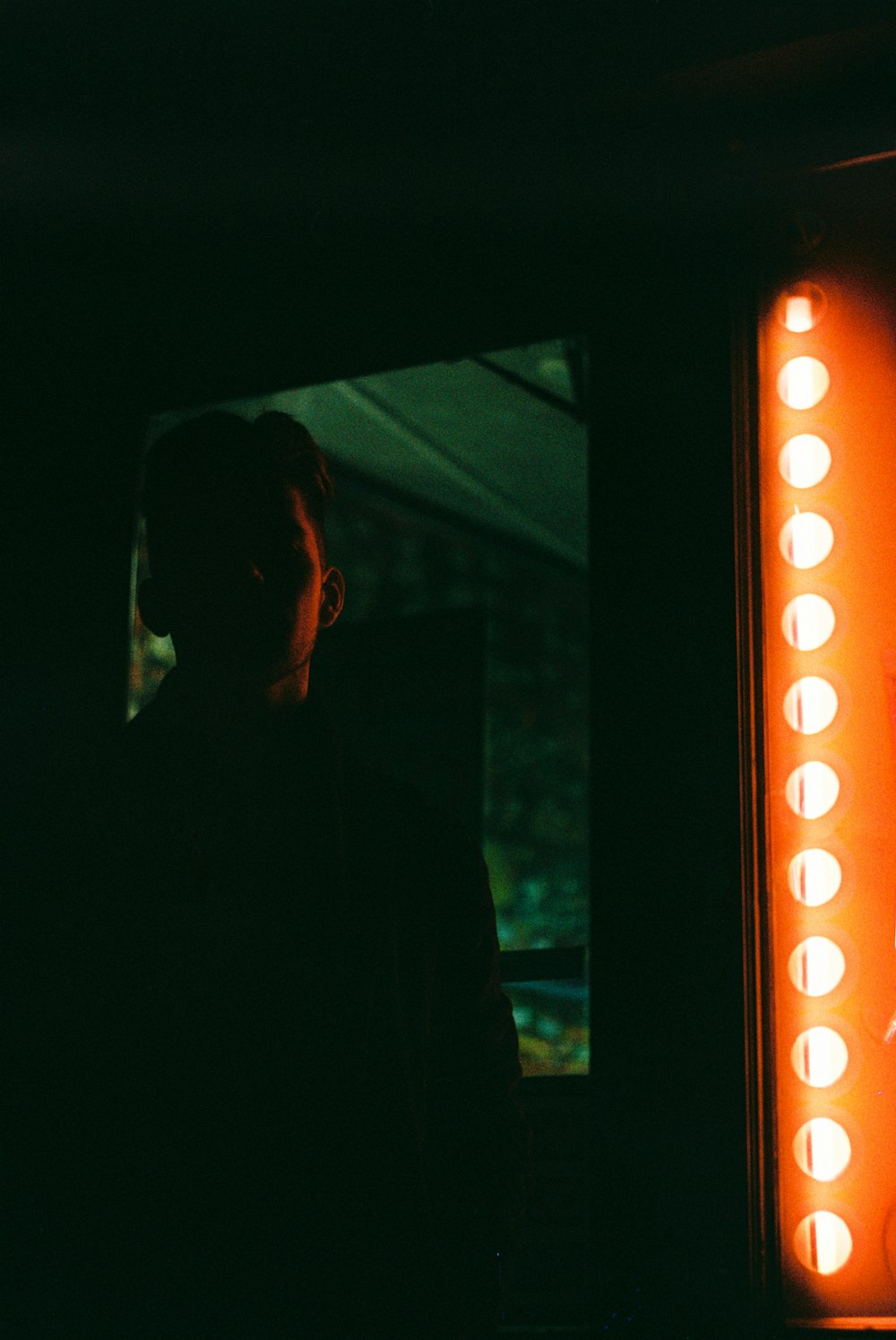 man standing near orange LED sign