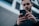 man wearing black sweater using smartphone