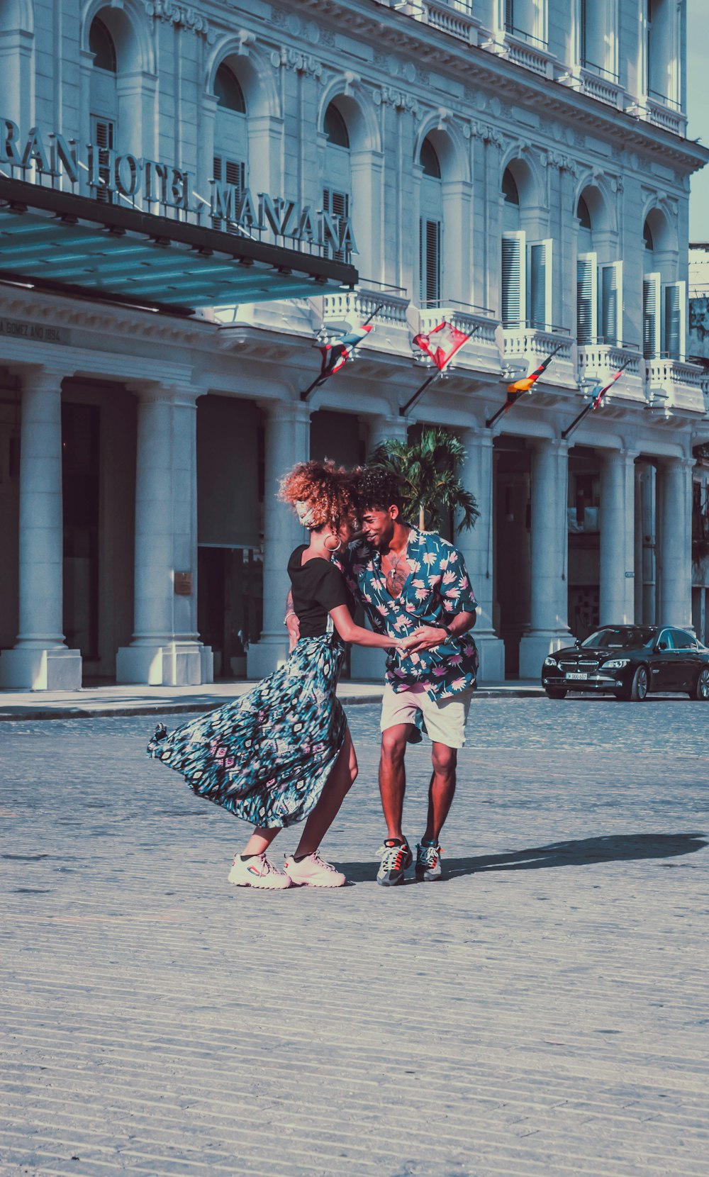 man with blue and pink floral shirt standing near woman