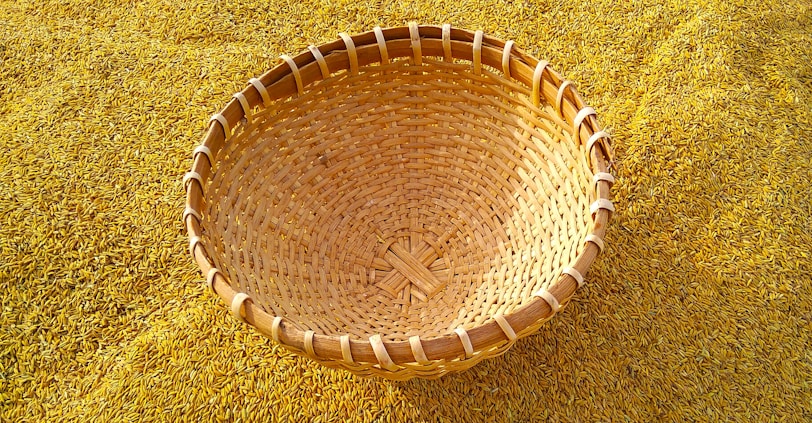 Close-up of golden basmati rice grains spilling from a traditional woven basket.