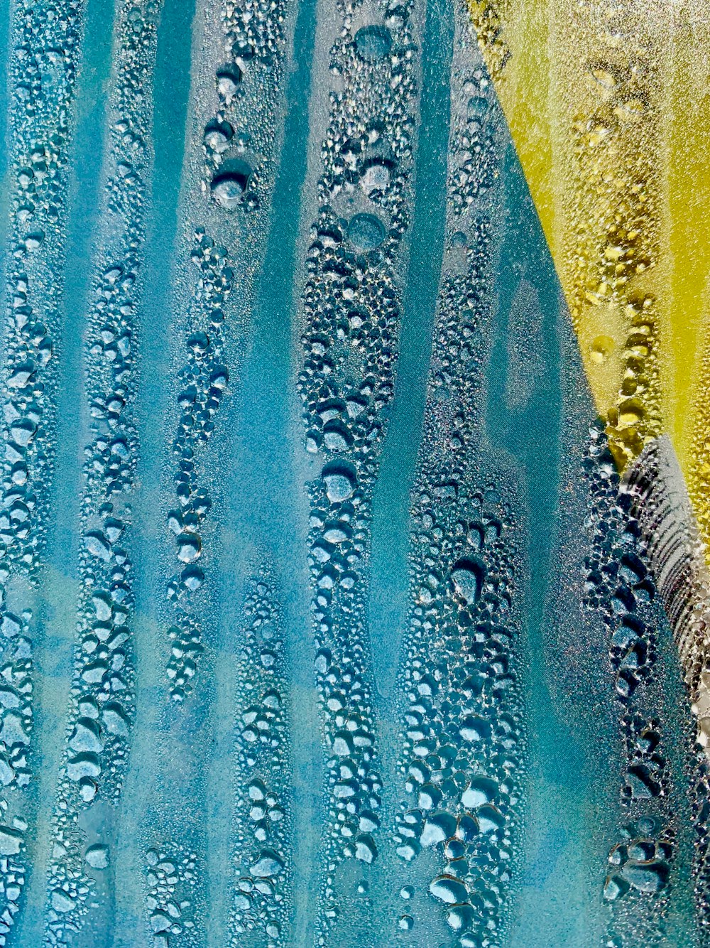 un dipinto blu e giallo con gocce d'acqua su di esso