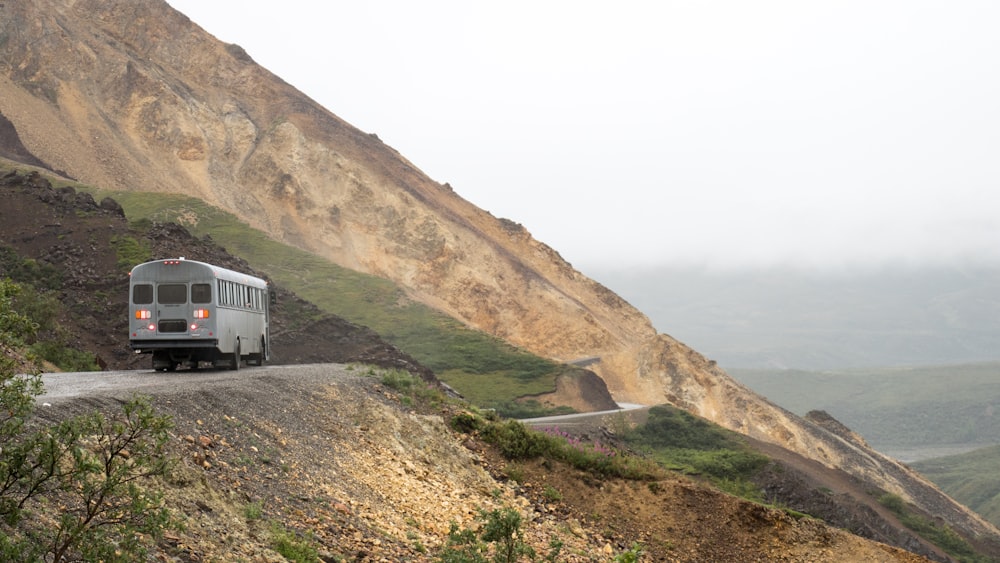 gray transit bus on mountain road