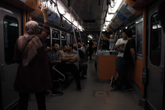 A lively group gathered inside a vintage Boston subway car, listening intently to a guide sharing historic tales.