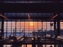 the sun is setting through the window of an airport
