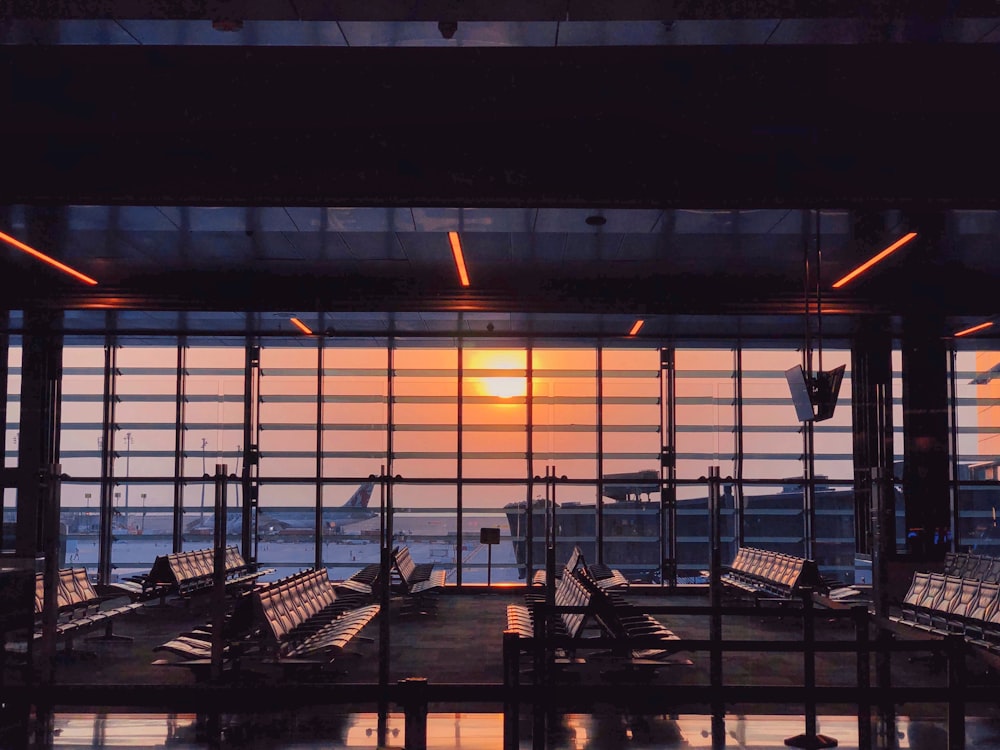 the sun is setting through the window of an airport