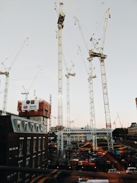 A wide shot of a modern urban construction site with cranes and building structures.