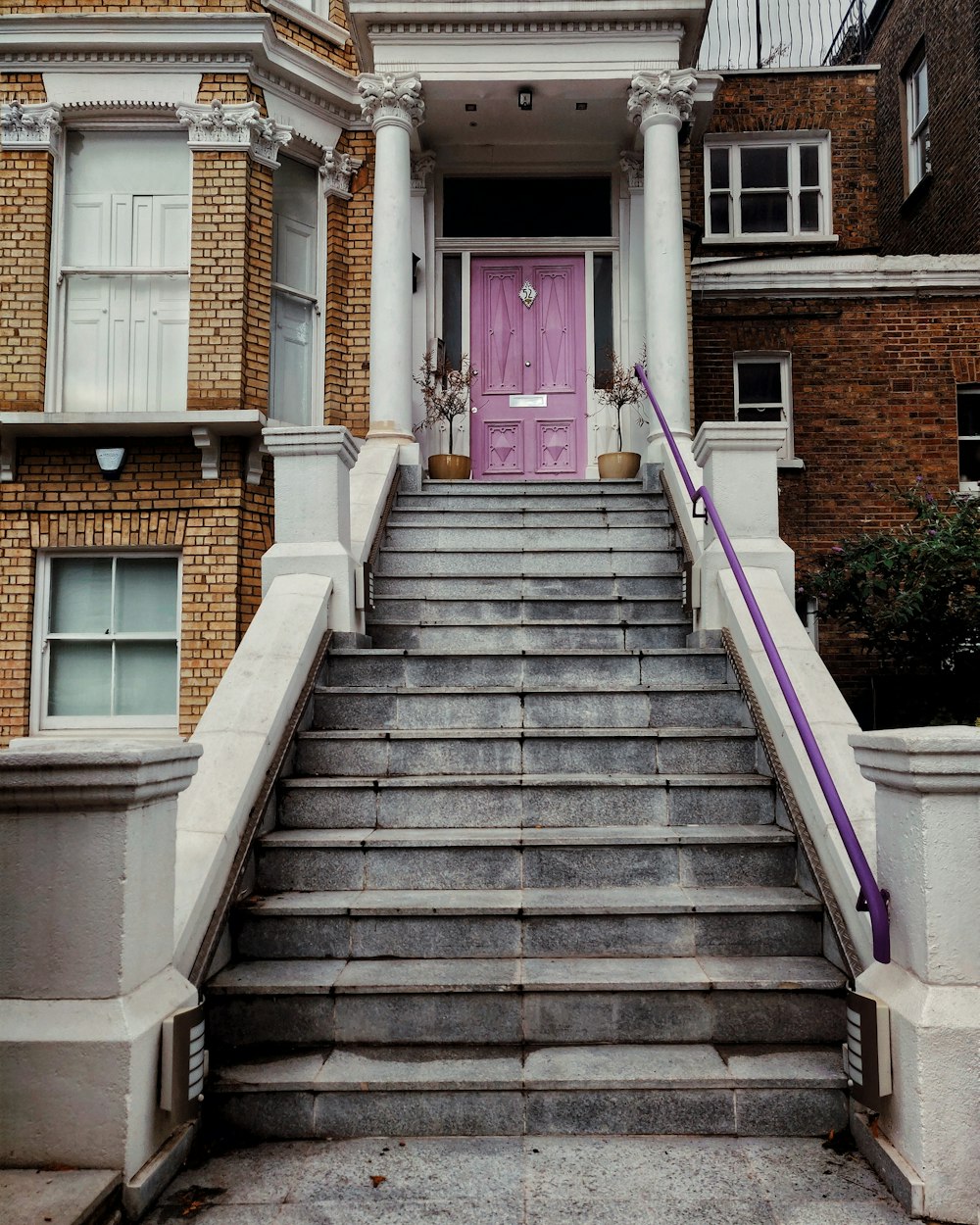 white concrete house showing closed purple wooden door
